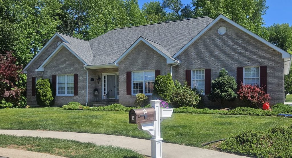 Brick ranch-style house with a manicured front yard and a white mailbox labeled 13 in the foreground.